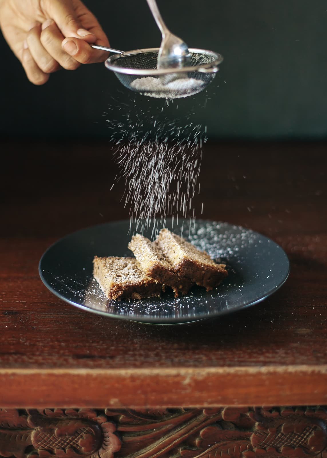 Fotografía profesional de un cocinero echando azur glaseado sobre un trozo de pastel