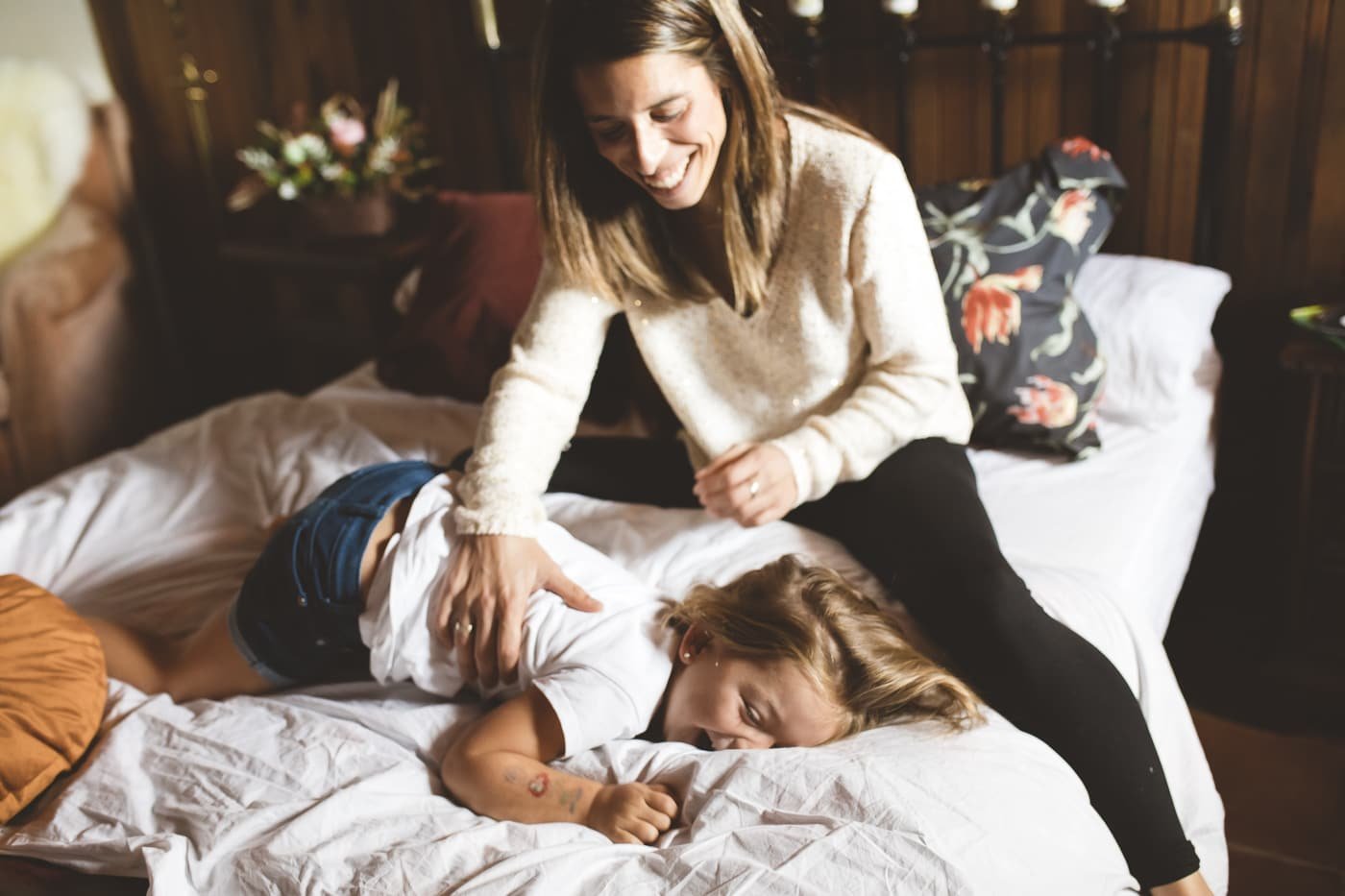 Fotografía profesional de una madre y su hija divirtiéndose en su habitación en una casa rural