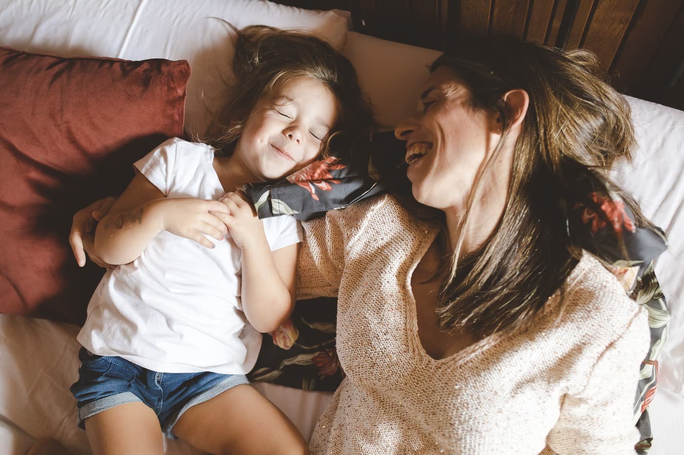 Fotografía profesional de retrato de una madre y una hija divirtiéndose en la cama en una casa rural