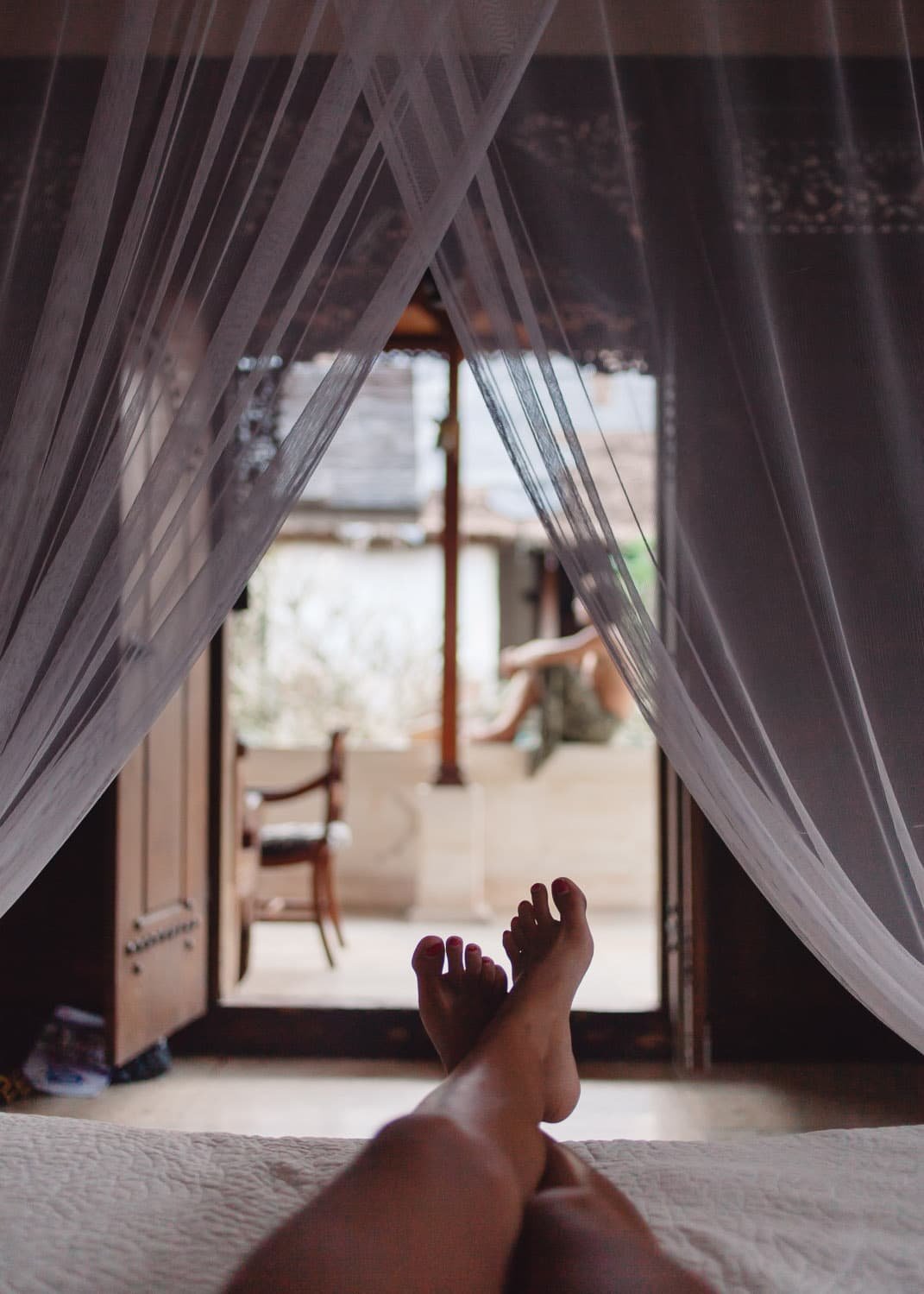 Fotografía para redes sociales de una modelo tumbada en la cama en el Honeymoon Guesthouse en Bali