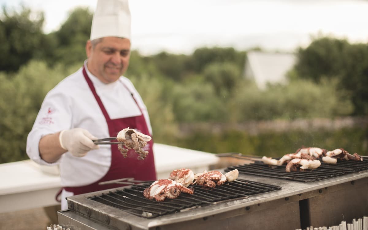 Fotografía profesional de un cocinero haciendo un pulpo a la plancha