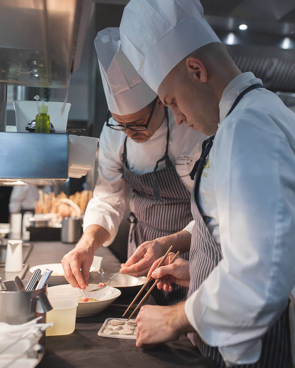 Fotografía profesional de dos cocineros preparando un postre