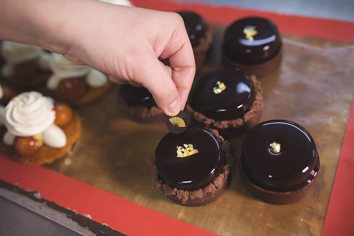 Fotografía profesional de una persona poniendo el logo de mandarín oriental sobre un postre de chocolate