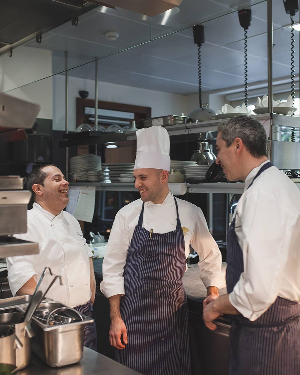 Cocineros de un restaurante con estrellas michelín hablando entre ellos